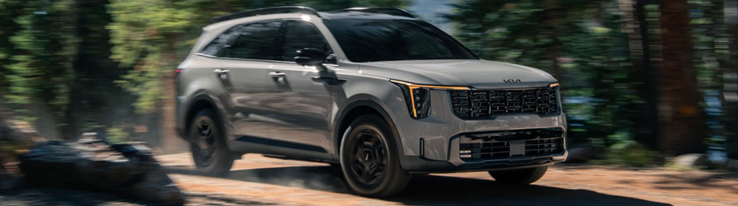 2025 Kia Sorento driving down a rural road