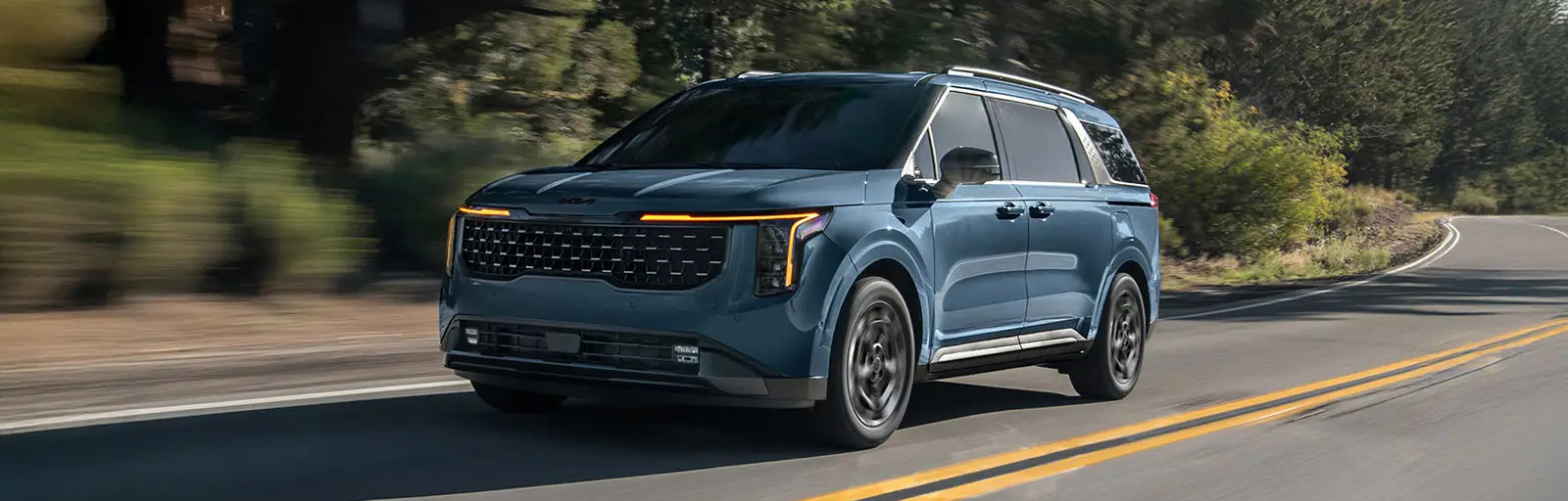 2026 Kia Carnival driving on open road in daylight