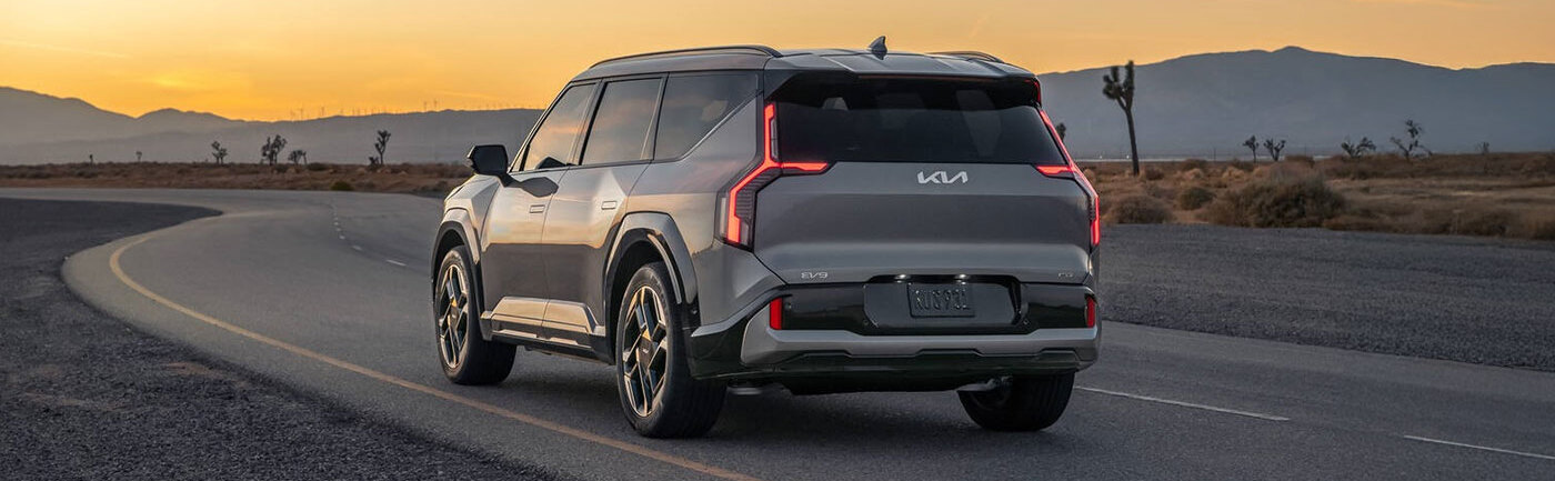 Exterior of 2026 Kia EV parked on road during dusk.