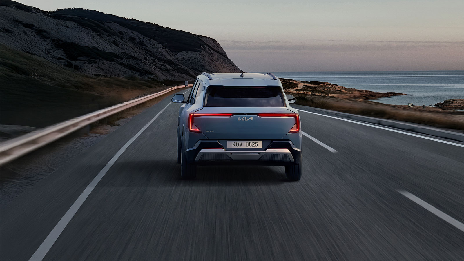 Rear exterior shot of 2026 Kia EV5 driving on road