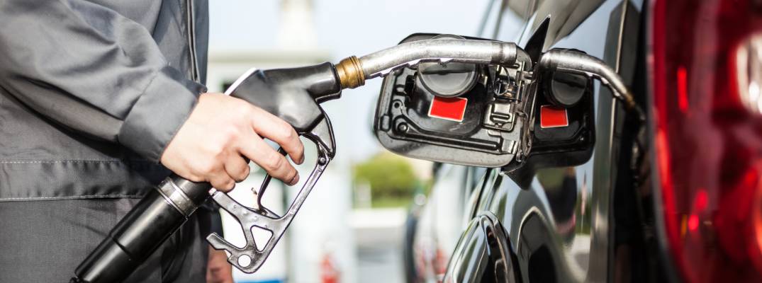 Unknown person filling vehicle up with fuel. 