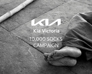 Bare feet resting on pavement beside a blanket, representing the need for clean, warm socks among people experiencing homelessness on Vancouver Island.