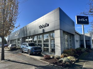Exterior view of Kia Victoria dealership on a sunny day in Victoria, BC, representing the dealership’s commitment to community involvement and local charity initiatives like the 10,000 Socks Campaign with Cool Aid Society.