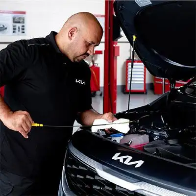 Kia technician checking oil