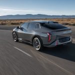 Rear quarter view of Kia EV4 on highway.