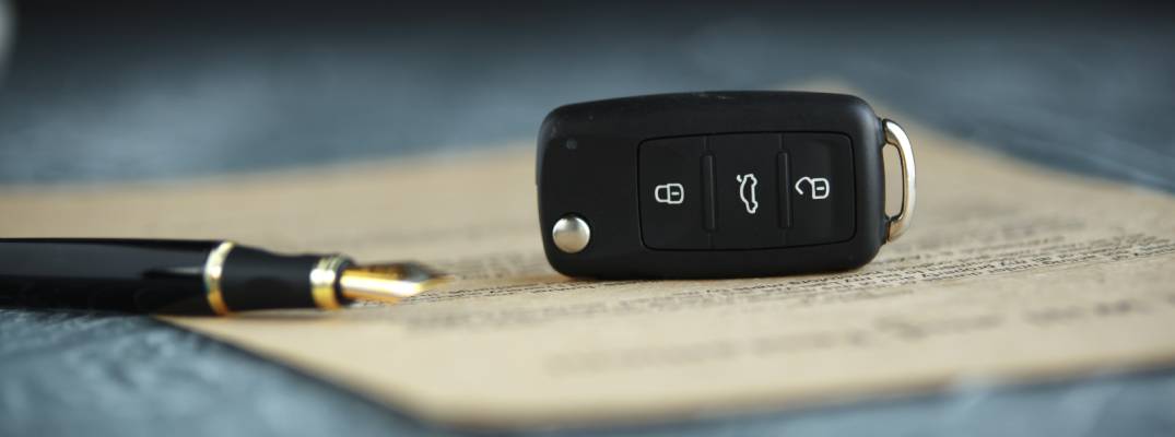 Pen and car keys sitting on top of a piece of paper