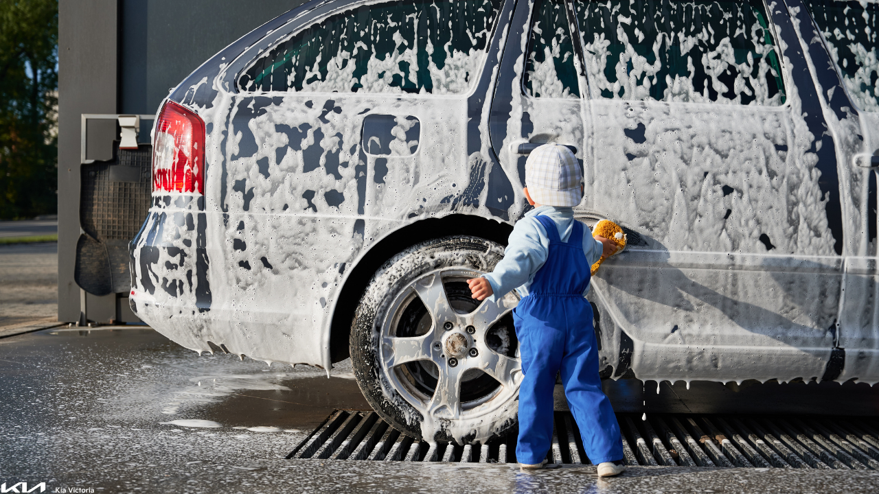 Small child washing a soapy car