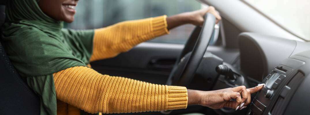 Unknown woman driving vehicle and using vehicle controls.